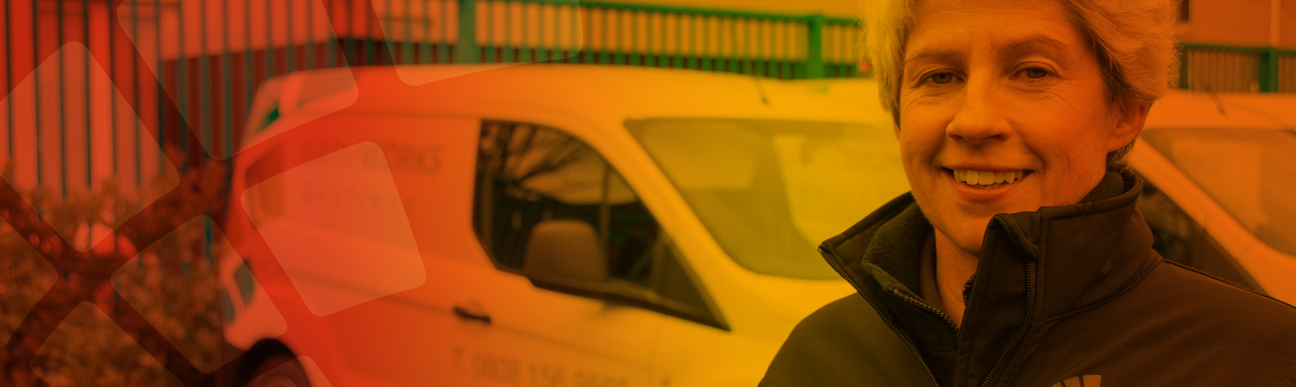 Smiling staff member stands with branded van