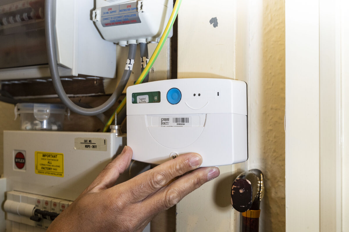 Person adjusting HeatSage heating control panel inside a cupboard.